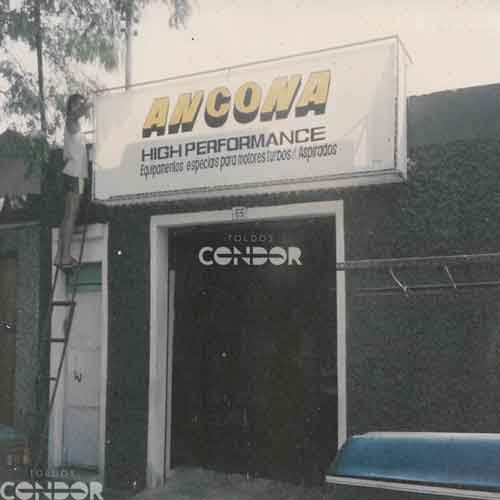 Homem instalando toldo na faixada de uma oficina mecanica.