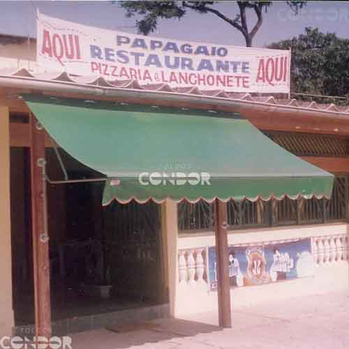 Toldo retrátil aberto protegendo a entrada de um restaurante.