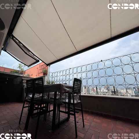 mesa debaixo de dois toldos em uma cobertura com vista para a cidade de são paulo