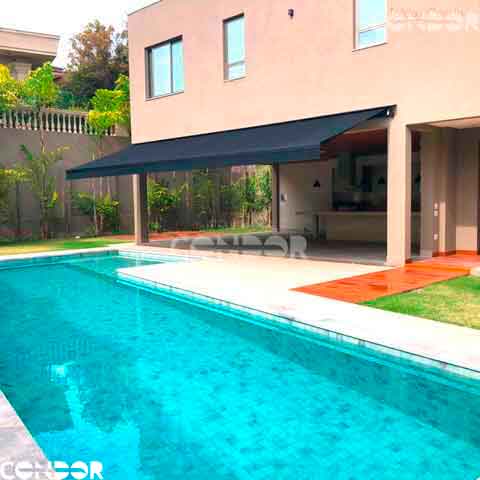 um toldo articulado premium junto a uma piscina em uma area gurmet
