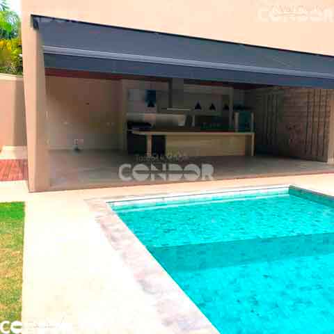 toldo articulado premium com lona preta cobrindo parcialmente um piscina