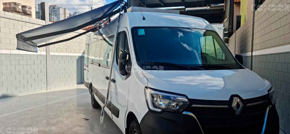Van Renault Master com toldo instalado no teto abrindo para a lateral