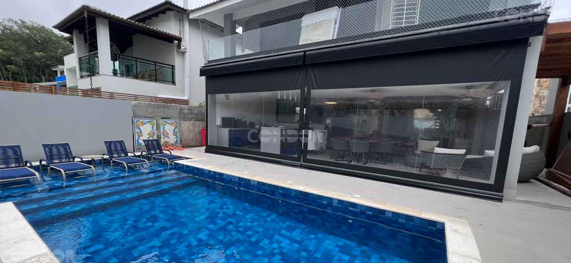 toldos cortinas verticais fechados separando a area gourmet da area aberta com piscina.