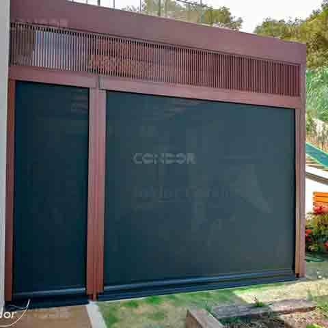 Toldos Premium Blocker instalados em um deck de madeira com estruta para pérgola, protegendo a área interna.