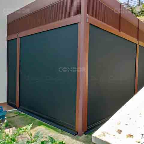 Toldos Premium Blocker instalados em um deck de madeira com estruta para pérgola, protegendo a área interna.