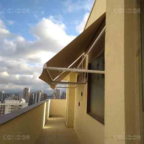 toldos retráteis abertos instalados em uma cobertura com vista para a cidade.