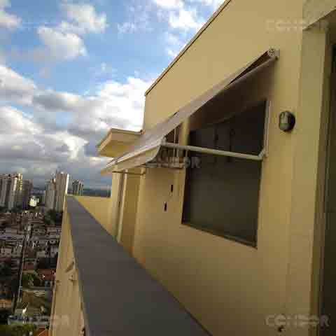 toldo retrátil basic aberto protegendo uma grande janela da luz do sol.