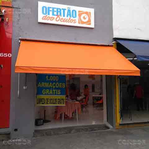 loja de óculos com toldo retrátil basic laranja instalado na faixada