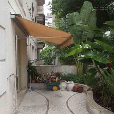 jardim com plantas, vajos de flor e um toldo retrátil basic os protegendo do sol e da chuva.