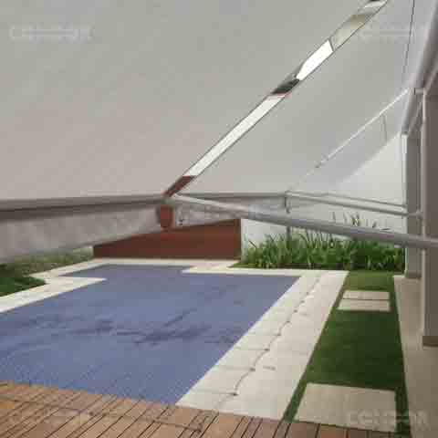 toldos retráteis abertos protegendo uma area gourmet com vista para a piscina.