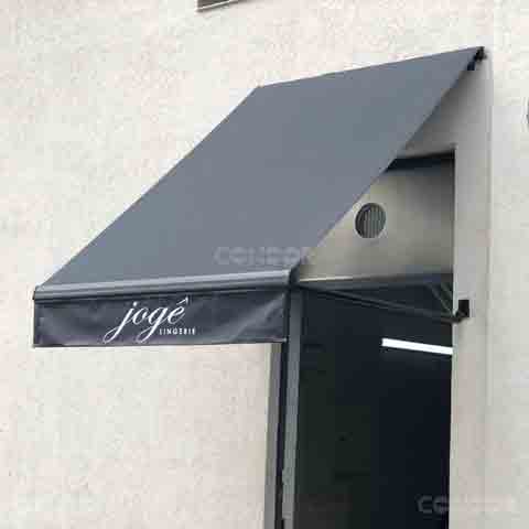 toldo retrátil basic com logo instalado na porta de entrada de uma loja.