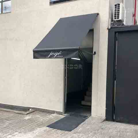 toldo retrátil basic com logo instalado na porta de entrada de uma loja.