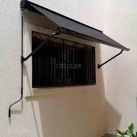 toldo retrátil aberto protegendo uma janela com grades.