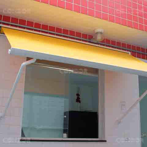 toldo retrátil premium box aberto protegendo uma porta de vidro.