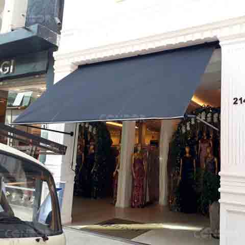 toldo retrátil premium box instalado em uma fachada de loja de vestidos de luxo.